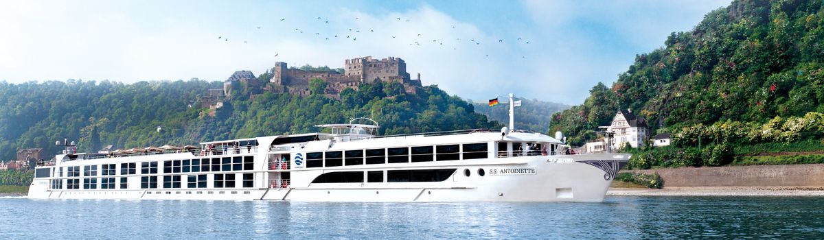 River cruise ship sailing on the Rhine River past a medieval castle in Germany