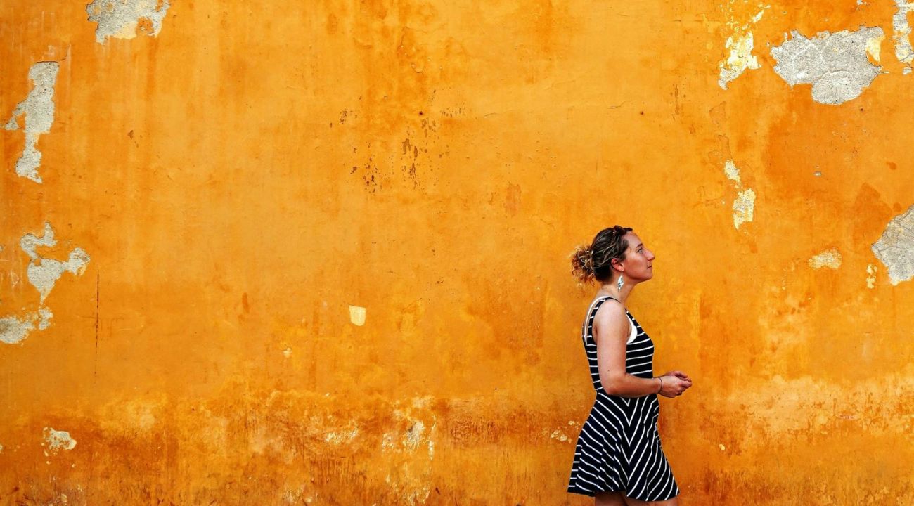 Solo female traveller walking through a city street, experiencing escorted tours vs independent travel