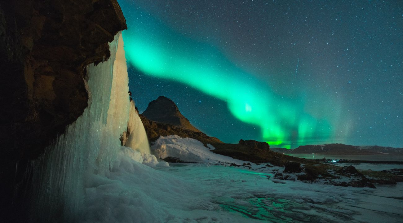 Northern lights over Icelandic landscape. Best time to visit Europe in Winter.