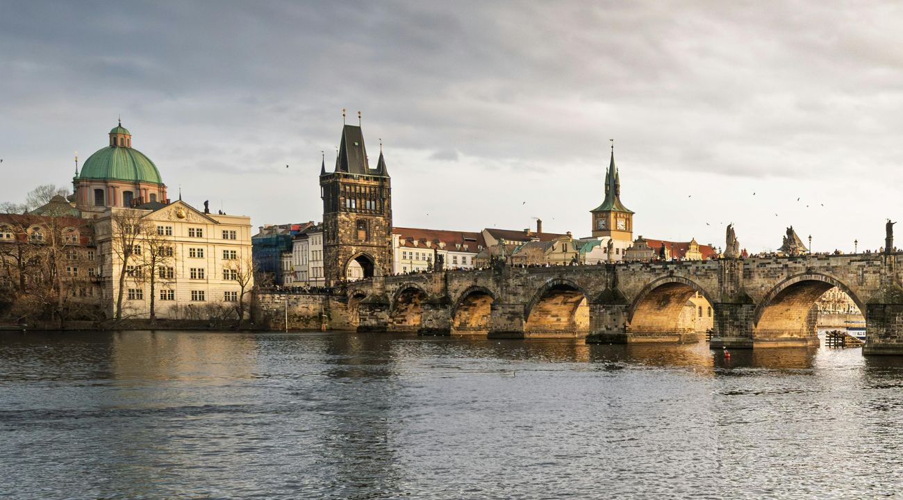 Charles Bridge in Prague over the Vltava River with historic towers and city skyline. One of the Best Easter holiday destinations in Europe.