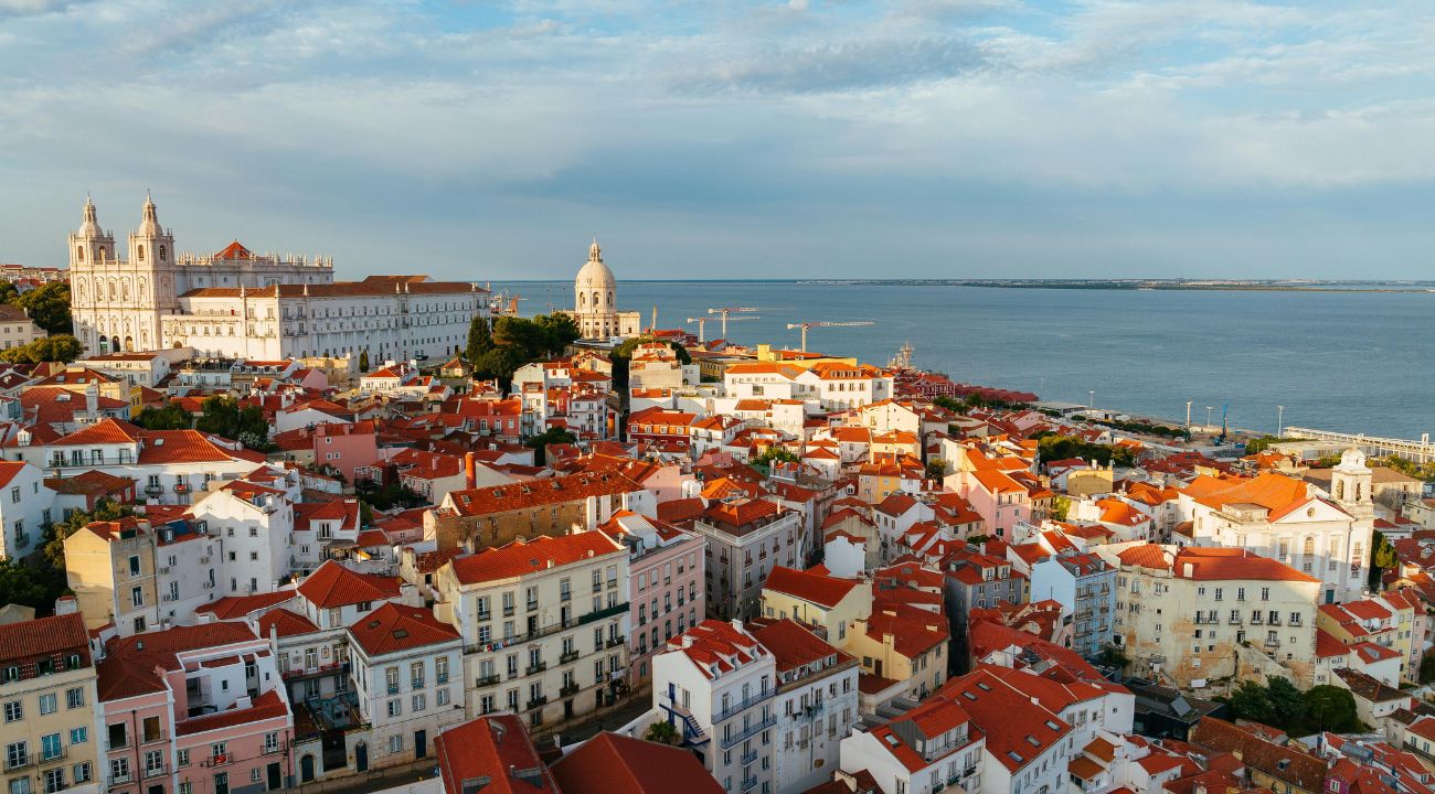 Aerial view of Lisbon with colourful buildings, hills, and the Tagus River in Portugal.