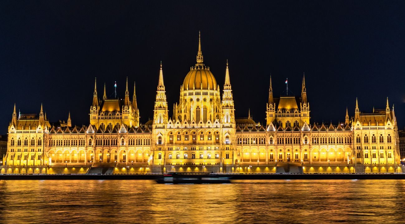 Hungarian Parliament Building in Budapest illuminated at night along the Danube River. One of the Best Easter holiday destinations in Europe.