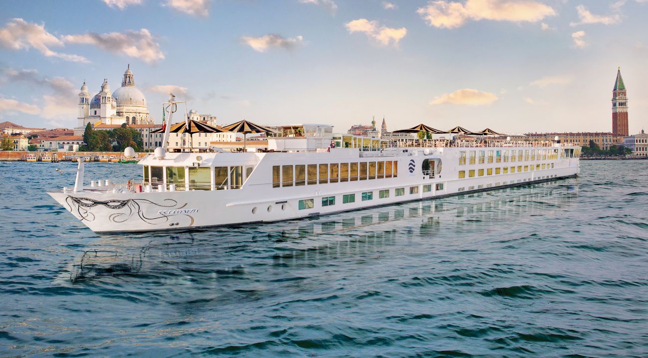River cruise ship sailing through the canals of Venice with historic buildings.