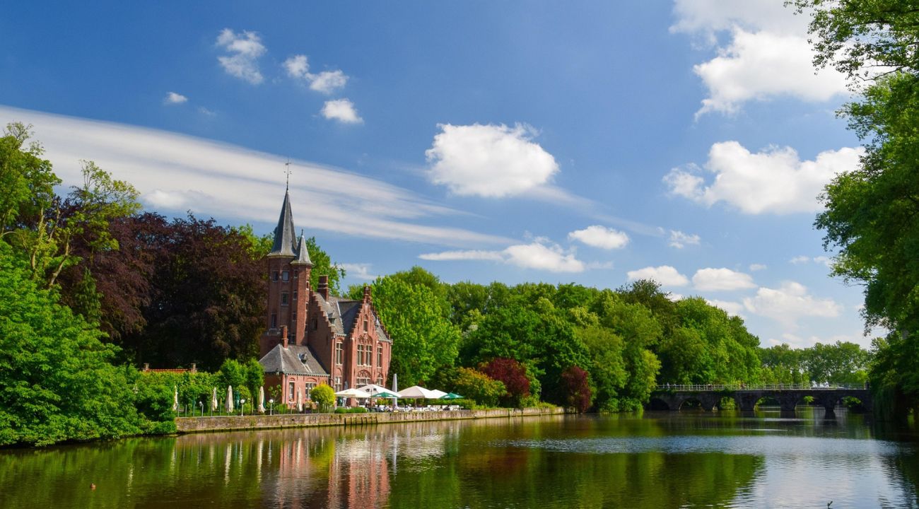 Canal in Bruges with historic buildings and reflections along the water in Belgium.