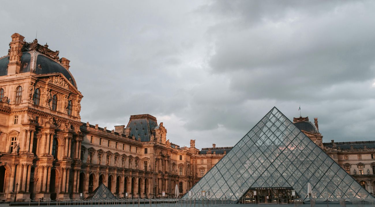 The Louvre Museum in Paris, France with its iconic glass pyramid entrance