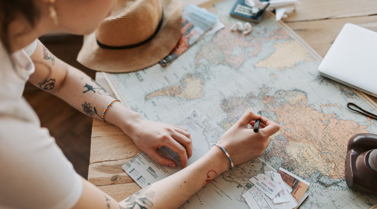 Person studying a world map and planning a travel route