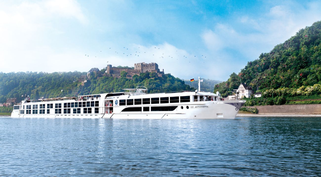 Rhine river cruise guide. River cruise ship sailing on the Rhine with a castle in the background