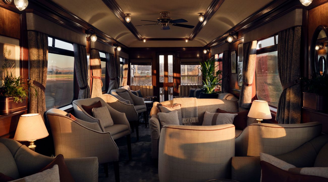 Bar and lounge area onboard a luxury train with panoramic views