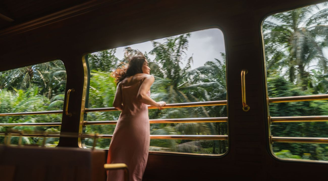 Guest looking out of a large window as a train moves through the landscape