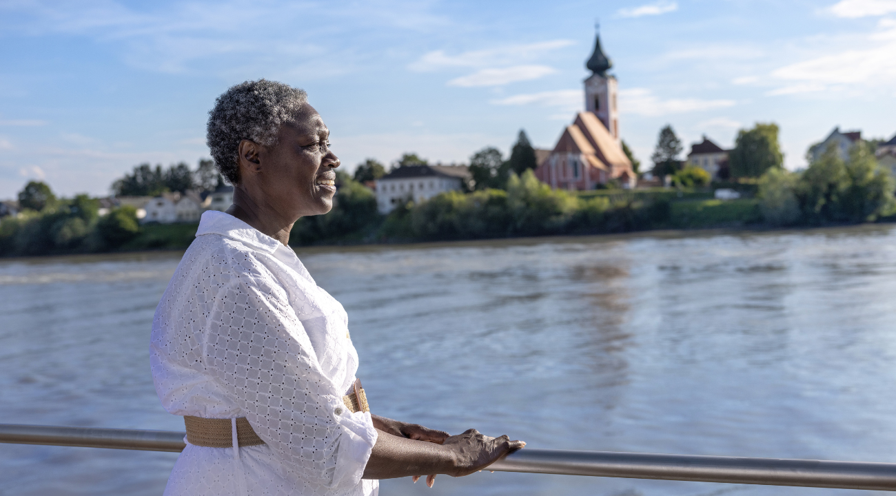 Woman on a river cruise deck enjoying views of the Danube River