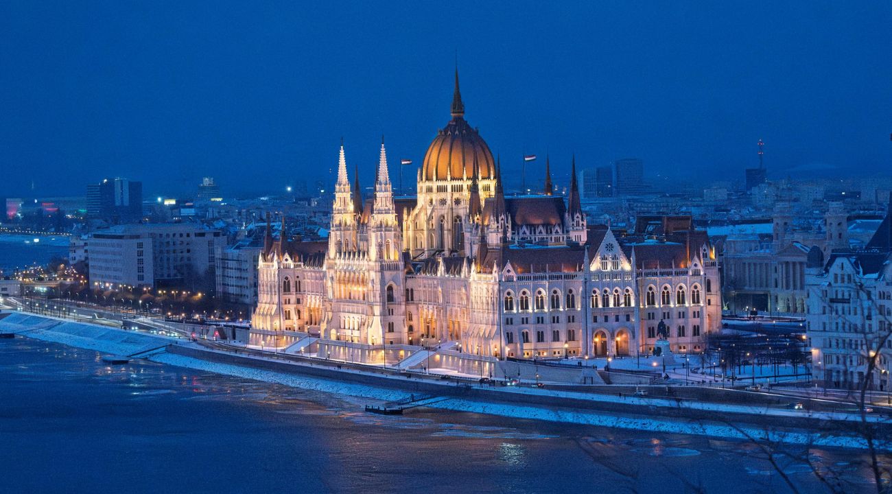 Budapest Parliament building lit at night, a cultural highlight for touring holidays in Europe