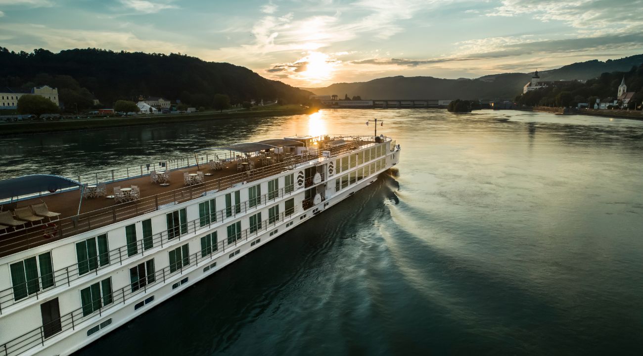 River cruise ship sailing into the sunset on a calm river