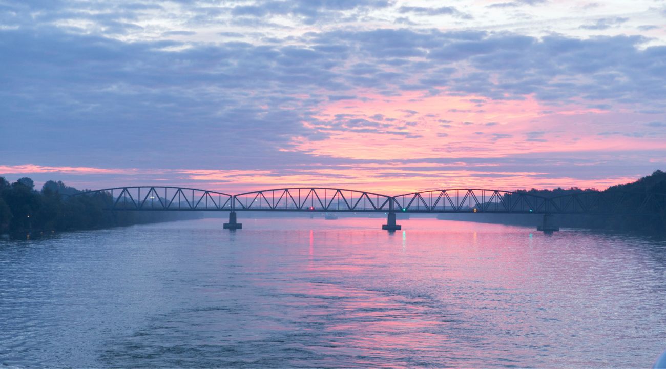 Sunset over the Danube River with a bridge spanning the water in a European city
