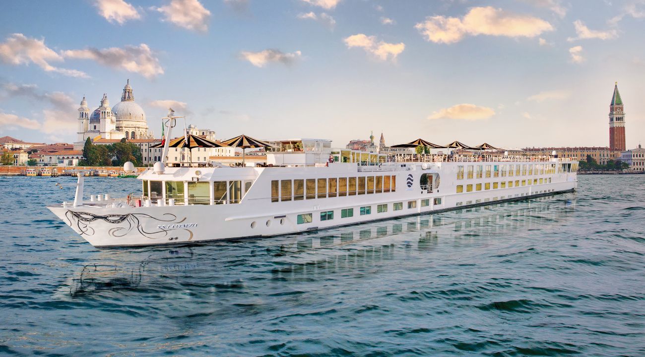 River cruise ship sailing through the canals of Venice with historic buildings and waterways in Italy