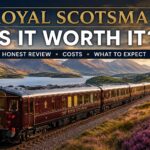 Royal Scotsman luxury train travelling through the Scottish Highlands beside a loch at sunset for a 2026 review article